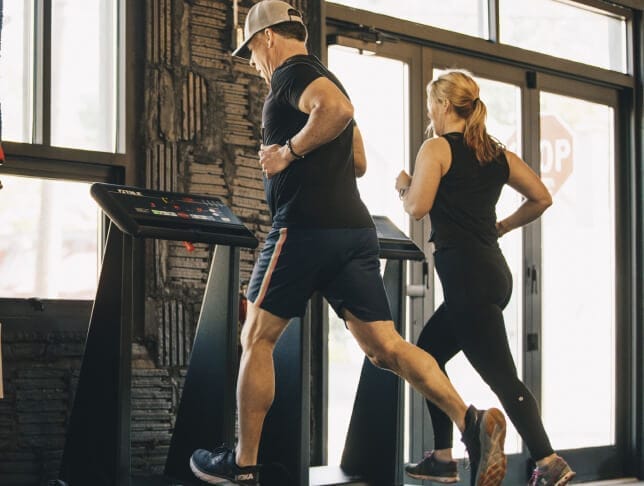 Man and woman running in our gym